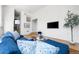 Bright living room featuring hardwood floors, a comfortable blue couch, and a mounted television at 1260 S Emerson St, Denver, CO 80210