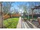 Spacious backyard featuring a patio with pergola, lush lawn, mature trees, and charming landscaping at 1711 Spruce St, Denver, CO 80220