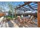 Backyard with a wooden pergola provides shade for outdoor dining, set on a patio with a view of the yard at 1711 Spruce St, Denver, CO 80220