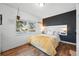Sunlit bedroom with large window, sleek headboard, and wood floors at 1711 Spruce St, Denver, CO 80220