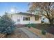 Charming home featuring a well-manicured lawn, stone pathway, and flourishing trees at 1711 Spruce St, Denver, CO 80220