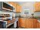 Well-lit kitchen with wooden cabinets, stainless steel appliances, and black countertop at 1711 Spruce St, Denver, CO 80220