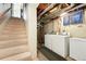 A convenient laundry room with washer, dryer, and ample storage located adjacent to the carpeted basement staircase at 1711 Spruce St, Denver, CO 80220