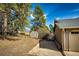 View of the backyard with grass, trees, and a shed at 36635 View Ridge Dr, Elizabeth, CO 80107