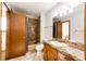 Bathroom showcasing tiled shower-tub, single sink vanity, and wood cabinets at 36635 View Ridge Dr, Elizabeth, CO 80107