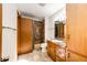 Bathroom features tiled shower-tub, single sink vanity, and wood cabinets at 36635 View Ridge Dr, Elizabeth, CO 80107