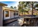 Exterior view showcasing a spacious wooden deck and access to the home's front door, set against a backdrop of mature trees at 36635 View Ridge Dr, Elizabeth, CO 80107