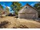 Detached two-car garage with a concrete driveway, surrounded by mature trees at 36635 View Ridge Dr, Elizabeth, CO 80107