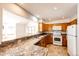 Well-lit kitchen boasting white appliances and a breakfast bar overlooking an adjacent living space at 36635 View Ridge Dr, Elizabeth, CO 80107