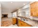 Kitchen with stainless steel appliances and wooden cabinetry, flowing into a spacious living area at 36635 View Ridge Dr, Elizabeth, CO 80107