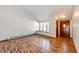 Bright living room featuring wood flooring, large window with built-in bench, and front door access at 36635 View Ridge Dr, Elizabeth, CO 80107