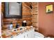 Charming powder room with a unique tile countertop, log walls, and rustic decor, adding character to the home at 4560 Hilltop Rd, Evergreen, CO 80439