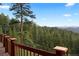 Expansive deck offering breathtaking panoramic views of the surrounding evergreen forest and distant mountain ranges at 4560 Hilltop Rd, Evergreen, CO 80439