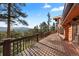 Large wooden deck providing picturesque views of the lush forest and mountain scenery; perfect for relaxation and entertainment at 4560 Hilltop Rd, Evergreen, CO 80439