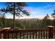 Beautiful mountain views from the deck's wood railing overlooking an expansive forest at 4560 Hilltop Rd, Evergreen, CO 80439