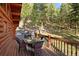 Outdoor dining area on deck with views of the forest and mountains, perfect for enjoying meals in nature at 4560 Hilltop Rd, Evergreen, CO 80439