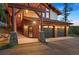 Beautiful home featuring a two-car garage, stone accents, porte cochere, covered entry, and mature trees at 4560 Hilltop Rd, Evergreen, CO 80439