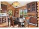 Log-cabin kitchen featuring wooden cabinets, stainless steel appliances, and dining table at 4560 Hilltop Rd, Evergreen, CO 80439