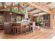Kitchen featuring a breakfast bar, wood beams and cabinets, granite counters, and stainless steel appliances at 4560 Hilltop Rd, Evergreen, CO 80439