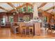 Kitchen with a breakfast bar, wood beams and cabinets, granite counters, stainless appliances and hardwood floors at 4560 Hilltop Rd, Evergreen, CO 80439