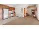 Kitchenette with wood cabinets, tile floor, and a view into a carpeted living space at 4560 Hilltop Rd, Evergreen, CO 80439