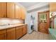Bright laundry room features wooden cabinets, utility sink, stackable washer/dryer, and wooden door to the exterior at 4560 Hilltop Rd, Evergreen, CO 80439