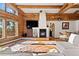 Living room featuring log beams, a stone fireplace, and large windows with natural lighting and a view at 4560 Hilltop Rd, Evergreen, CO 80439