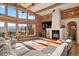 Living room boasting exposed log beams, stone fireplace, and mountain views at 4560 Hilltop Rd, Evergreen, CO 80439