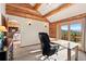 Log-cabin office with a desk and mountain view through sliding glass doors at 4560 Hilltop Rd, Evergreen, CO 80439