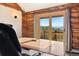 Log-cabin office with a view of mountains through sliding glass doors at 4560 Hilltop Rd, Evergreen, CO 80439