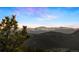 Scenic view of snow-capped mountains surrounded by lush green forests on a sunny day at 4560 Hilltop Rd, Evergreen, CO 80439