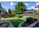 Well-maintained fenced backyard featuring a large shade tree and lush green grass at 9046 Sandpiper Dr, Frederick, CO 80504