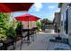 Backyard patio featuring seating, a red umbrella, mature foliage and a hot tub at 9046 Sandpiper Dr, Frederick, CO 80504