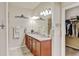 Bathroom featuring double sinks, granite countertop, walk in closet, and wood vanity at 9046 Sandpiper Dr, Frederick, CO 80504