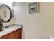 Cozy half bathroom featuring a granite-topped vanity and decorative artwork on the textured walls at 9046 Sandpiper Dr, Frederick, CO 80504