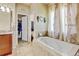 Relaxing bathroom with a soaking tub, separate vanity area, and closet for storage at 9046 Sandpiper Dr, Frederick, CO 80504