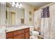 Full bathroom featuring a granite-topped vanity, a large mirror, and a shower with decorative shower curtain at 9046 Sandpiper Dr, Frederick, CO 80504