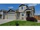 Attractive home with a large two-car garage, well-kept lawn, and inviting front porch with stone pillars at 9046 Sandpiper Dr, Frederick, CO 80504