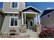 Welcoming front porch with stone pillars, tasteful landscaping, and a cozy sitting area with charming decor at 9046 Sandpiper Dr, Frederick, CO 80504