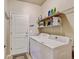 Bright laundry room featuring a washer, dryer, shelving and storage space for convenience at 9046 Sandpiper Dr, Frederick, CO 80504
