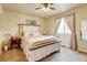 A serene main bedroom with a large window offering ample natural light and a charming white-washed bed at 9046 Sandpiper Dr, Frederick, CO 80504