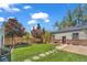 Spacious backyard featuring a manicured lawn, stepping stones, string lights, and privacy fence at 1300 Cherry St, Denver, CO 80220