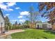 Landscaped backyard featuring a patio, manicured lawn, privacy fence, and mature trees at 1300 Cherry St, Denver, CO 80220