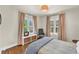 Cozy bedroom showcasing two bright windows and hardwood floors, complemented by neutral decor and a chair at 1300 Cherry St, Denver, CO 80220