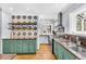 Cozy kitchen featuring jade cabinetry, a stainless steel range, and decorative backsplash at 1300 Cherry St, Denver, CO 80220
