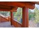 Balcony with wood beams and view of the treed lot in the distance at 7076 Boreas Rd, Larkspur, CO 80118