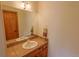 A bathroom with neutral paint, tile countertops, vanity, and light sconces at 7076 Boreas Rd, Larkspur, CO 80118