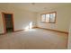 Spacious bedroom with neutral paint, carpet, and a large picture window for natural light at 7076 Boreas Rd, Larkspur, CO 80118