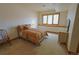 A cozy bedroom features neutral paint, carpet, and a lovely window with a window seat at 7076 Boreas Rd, Larkspur, CO 80118