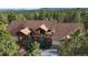 Beautiful home with wood features and a brown roof nestled in a mature forest at 7076 Boreas Rd, Larkspur, CO 80118